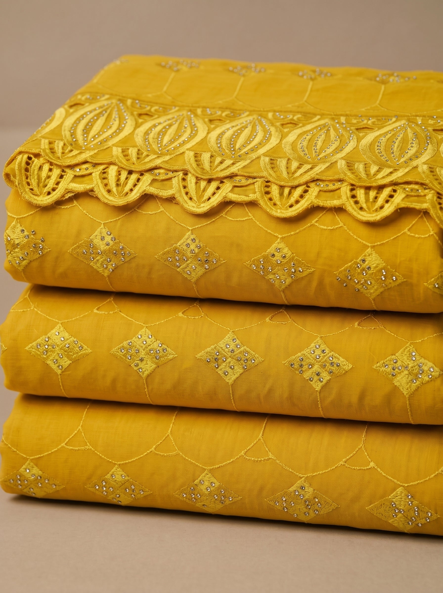 Vibrant mustard yellow Swiss voile featuring a structured diamond lattice pattern and ornate heavy-duty cutwork embroidery