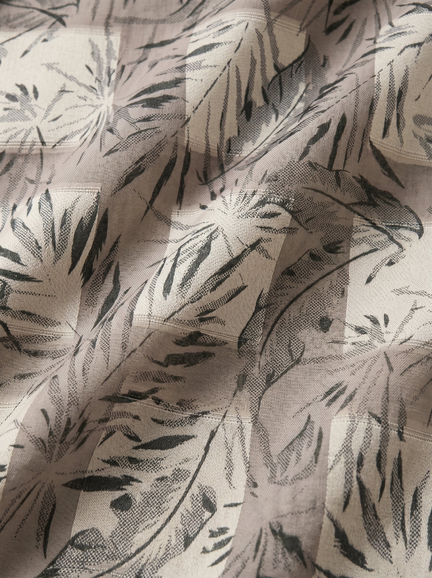 Unstitched Swiss voile featuring nature-inspired leaf motifs and intricate embroidery work
