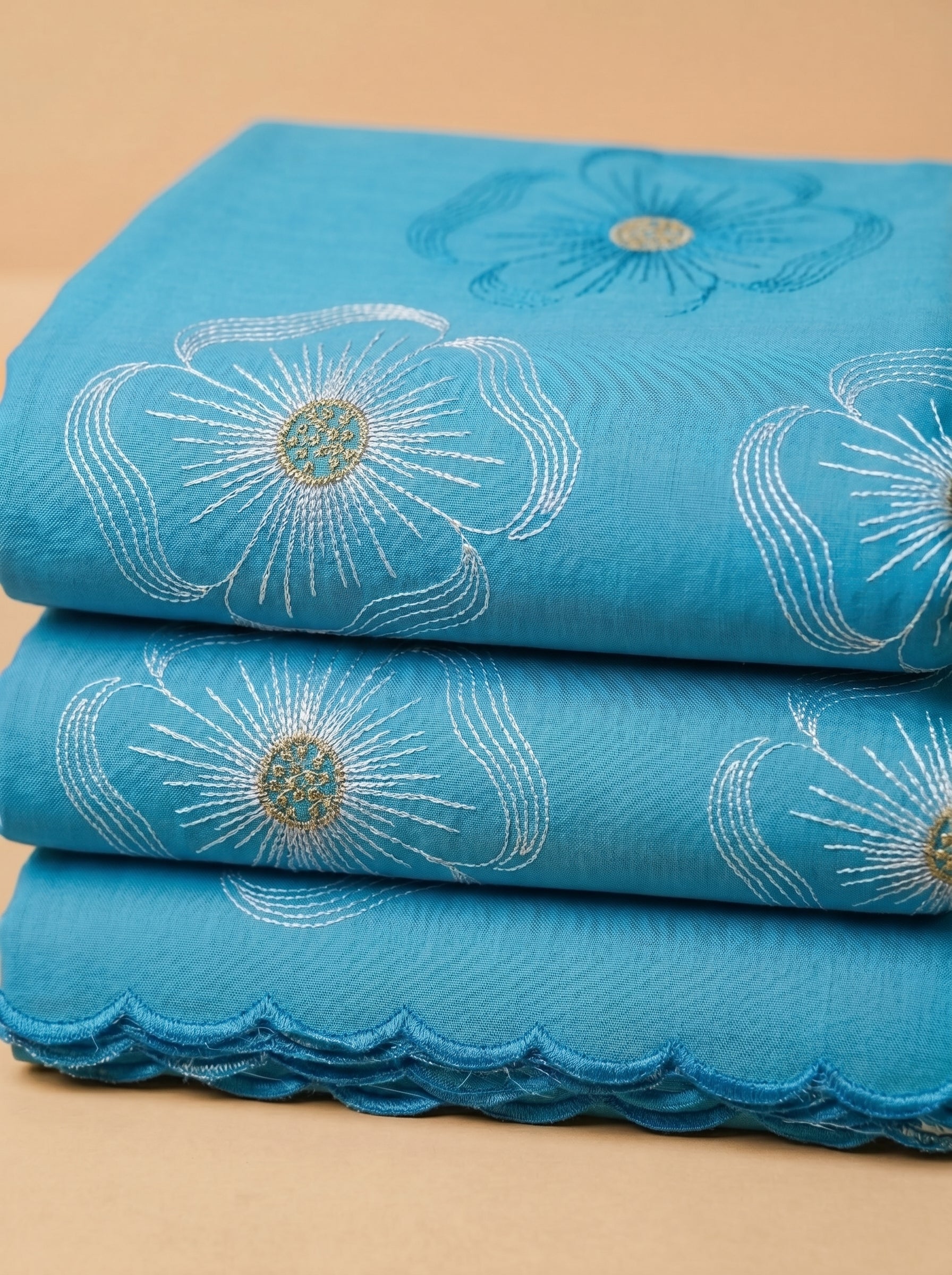 Premium azure blue Swiss voile featuring delicate cutwork floral embroidery and scalloped edges