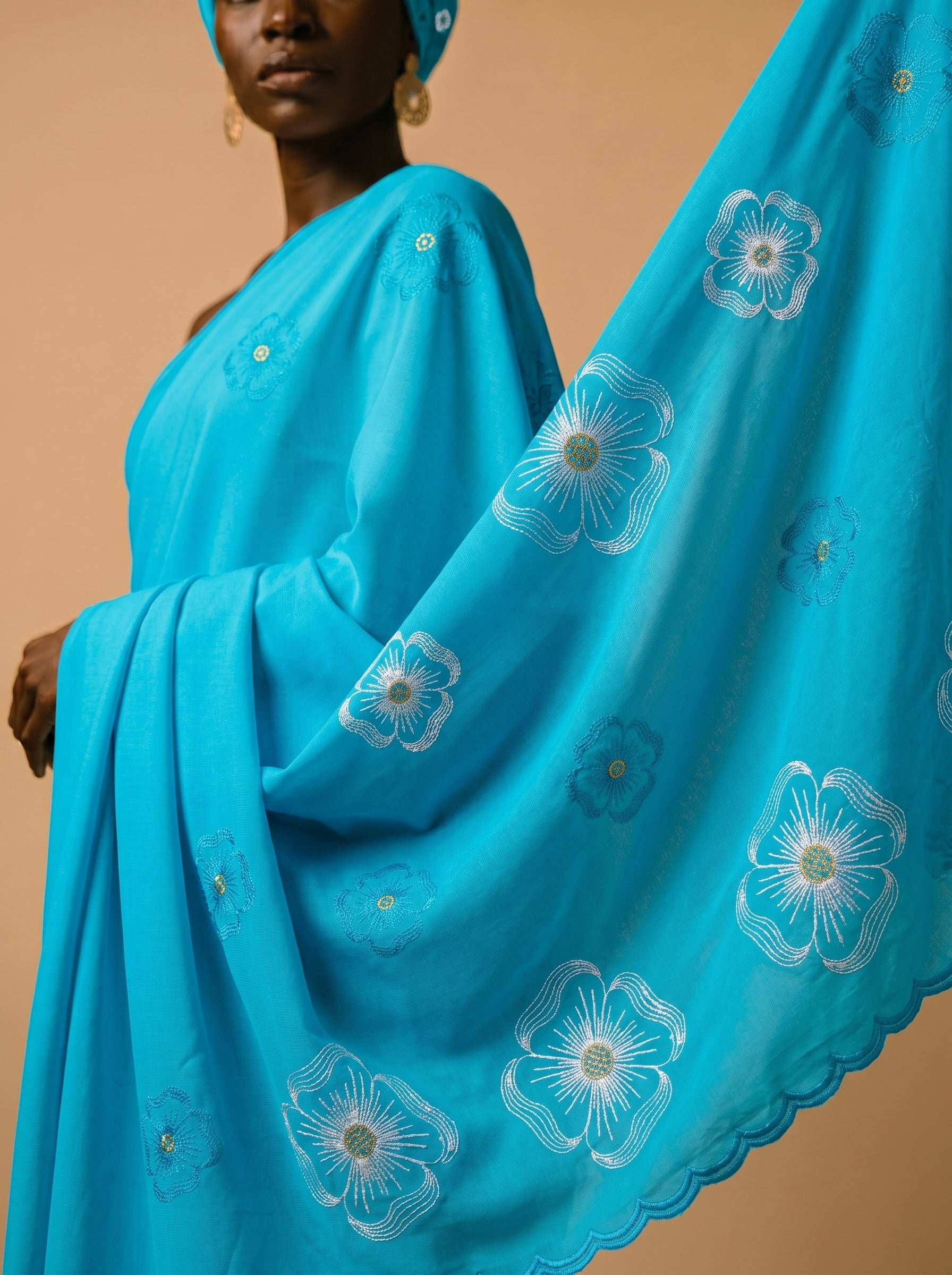 Premium azure blue Swiss voile featuring delicate cutwork floral embroidery and scalloped edges