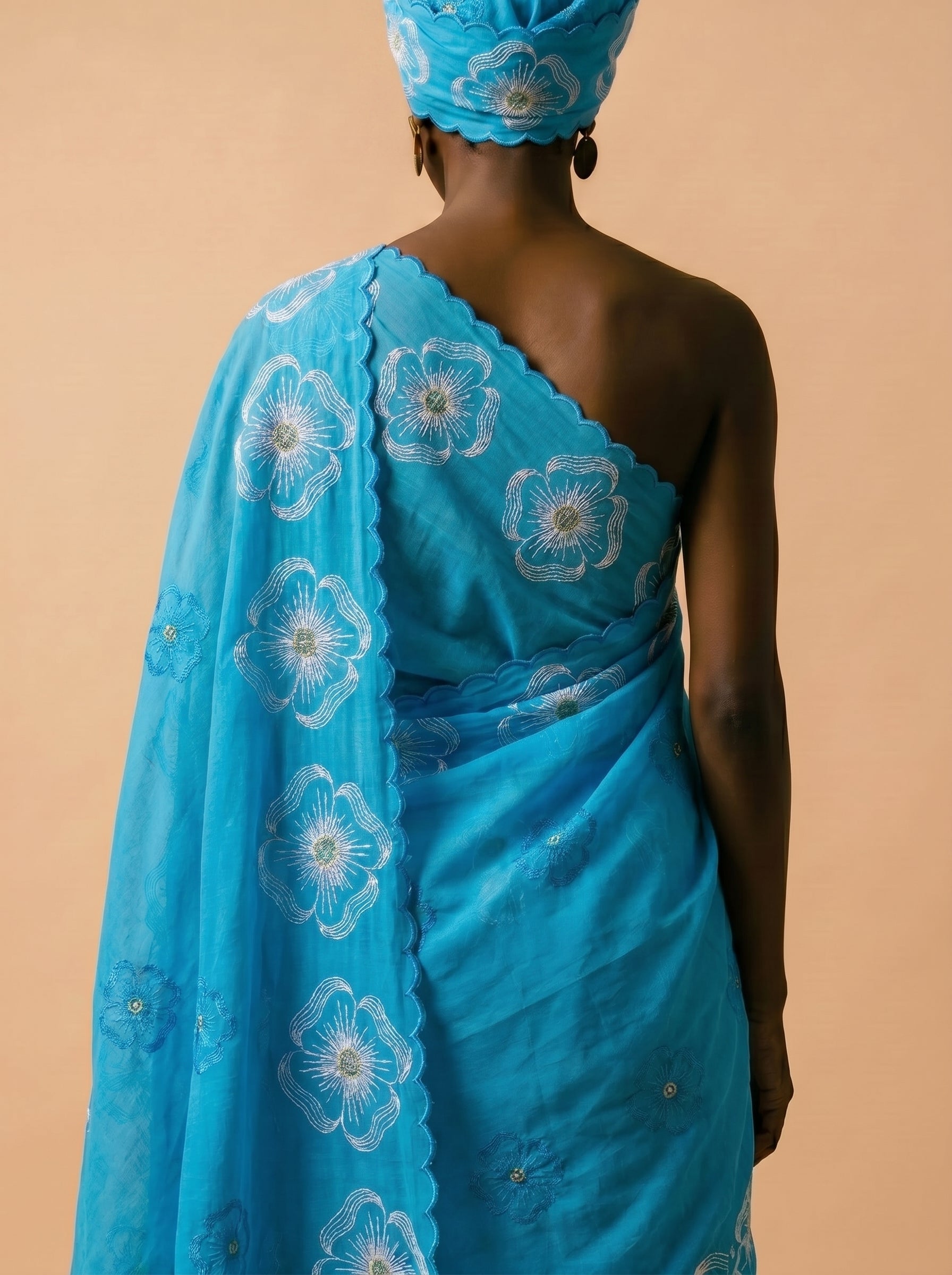 Premium azure blue Swiss voile featuring delicate cutwork floral embroidery and scalloped edges